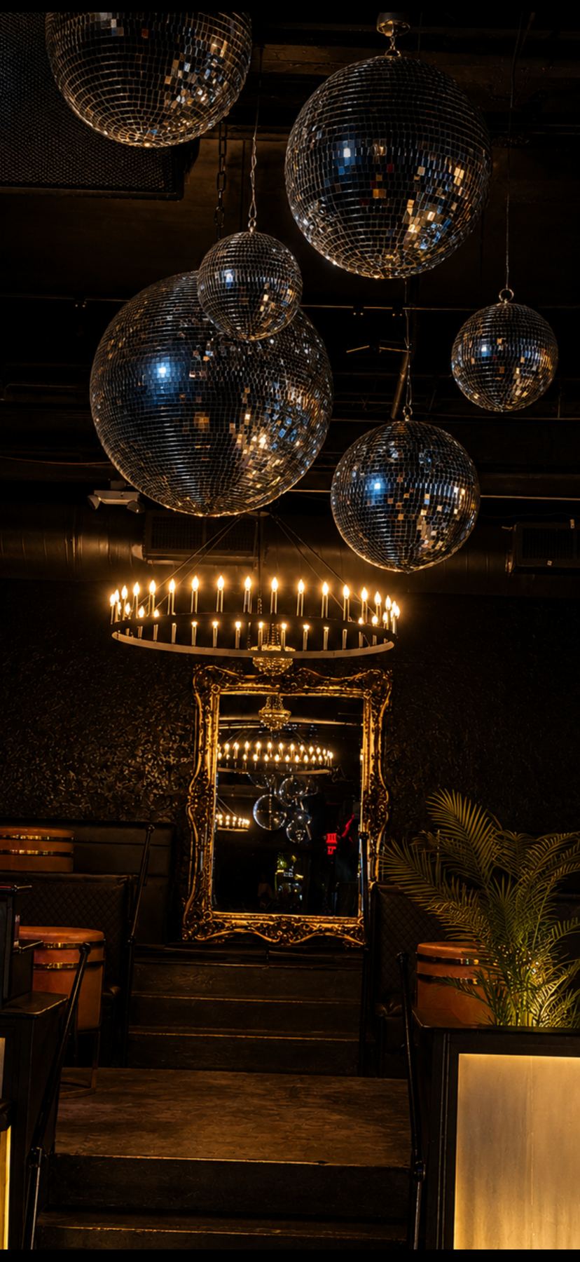 Disco balls over the ring chandelier and gold mirror
